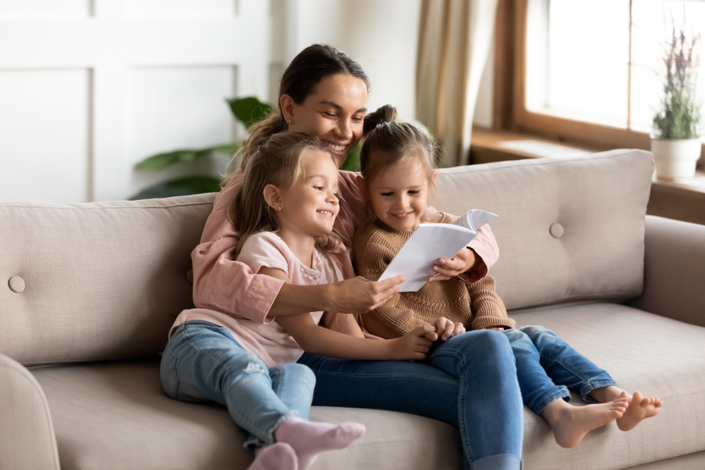 Happy,Family,Young,Mother,Babysitter,Hold,Read,Book,Relax,Embrace